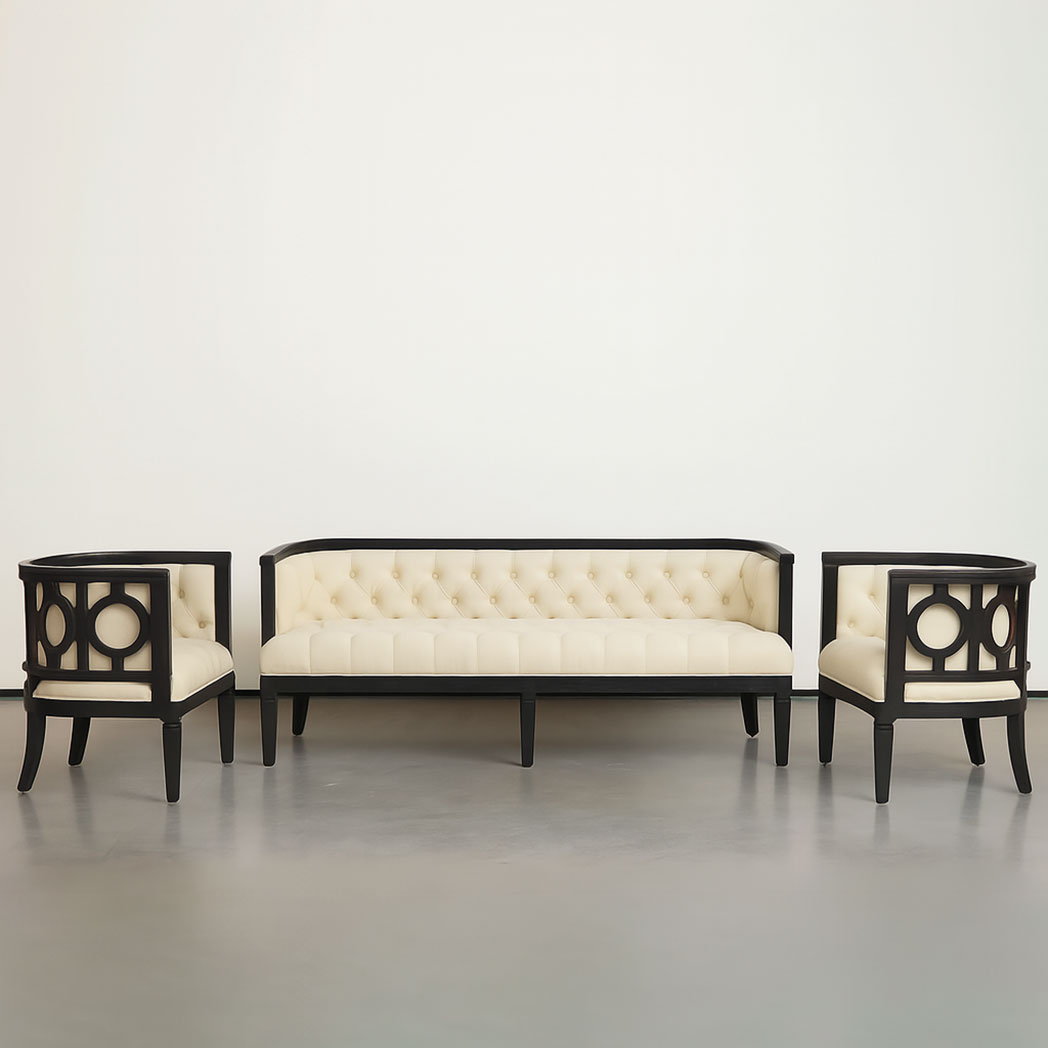 A sophisticated lounge seating set includes a three-seater sofa and two matching barrel-back chairs. The set features plush ivory tufted upholstery and a bold black wood frame with decorative circular cutouts. Ideal for luxury weddings, hotel lobbies, or VIP event lounges, this customizable set adds both style and comfort to any formal setting.