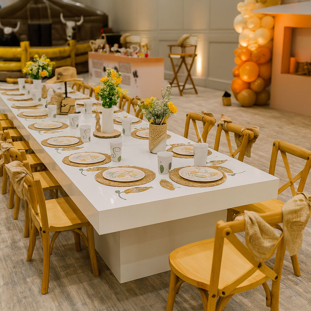 Modern acrylic kids dining table with wooden chairs styled for a western-themed children’s event with floral centerpieces and balloon décor