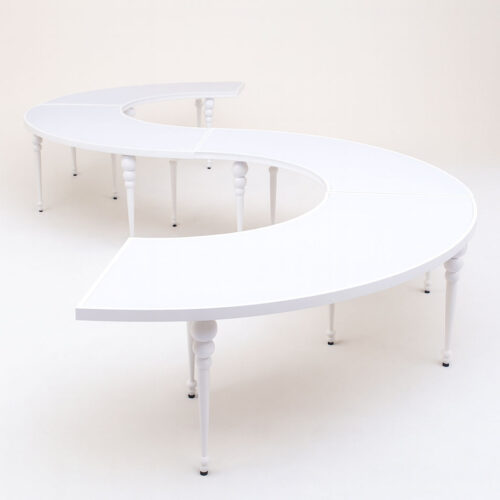 Modern kids serpentine table with glossy white acrylic top and polished stainless steel legs arranged in S-shaped configuration on clean white background