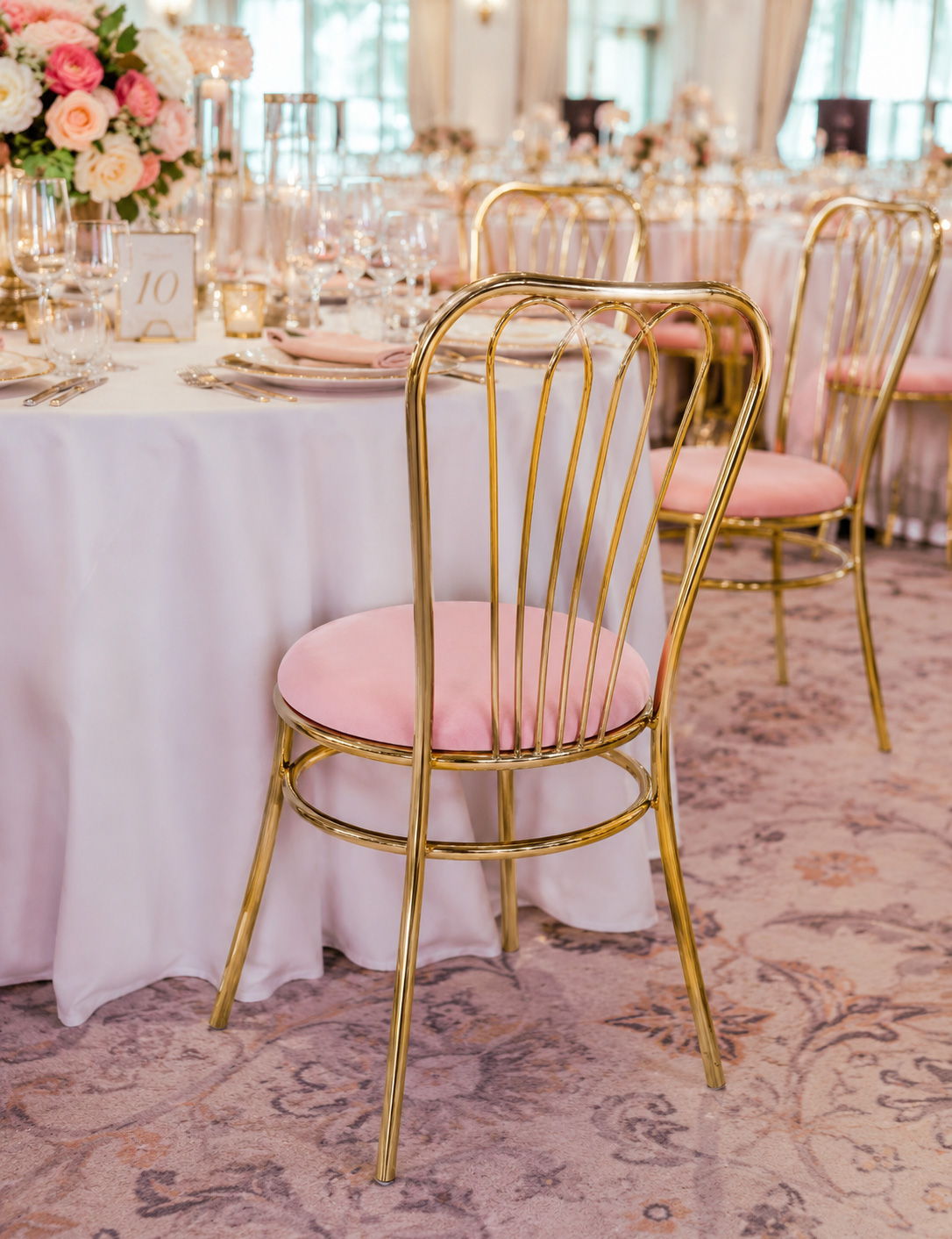 Luxury gold wedding chairs with pink velvet cushions in elegant wedding reception venue