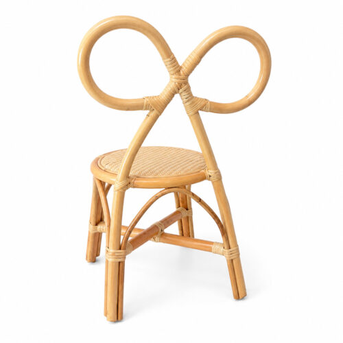 Natural-colored bow-back rattan chair for children with handwoven cane seat, shown in gallery view on pink-tiled flooring.