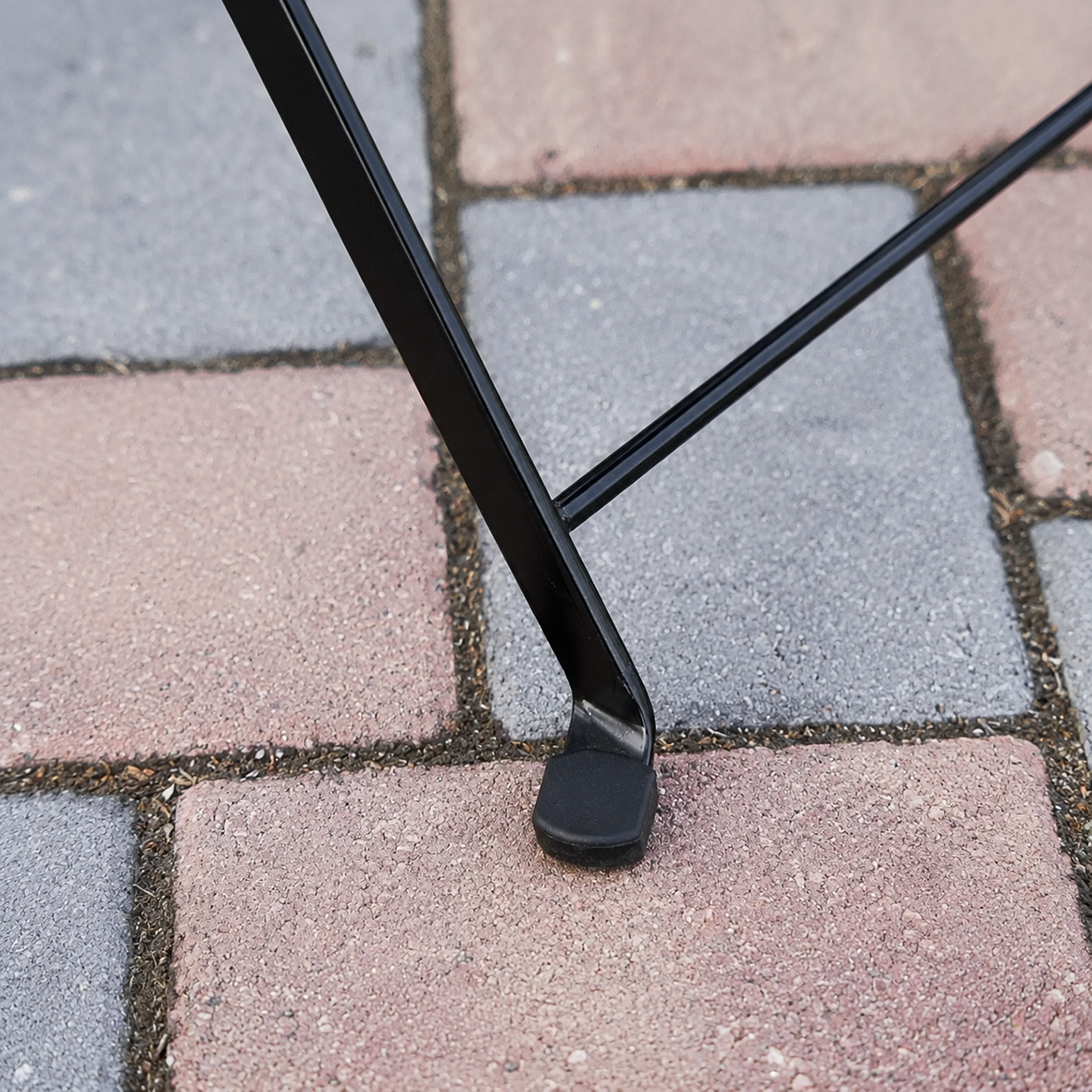 Close Up of Rustic Wood Slatted Bistro Folding Chair Rubber Foot and Black Metal Frame Detail