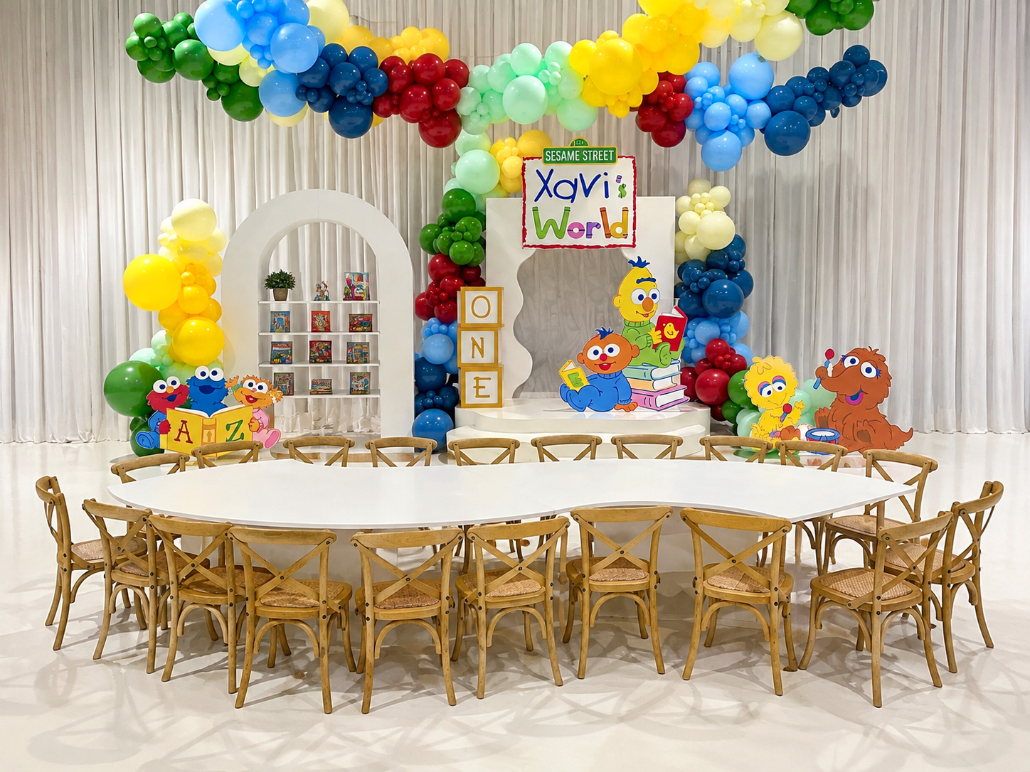 Natural wood cross back kids chairs arranged around a white event table